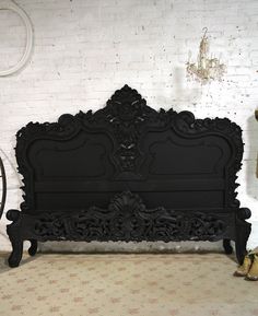 an old black bed in a room with white brick walls