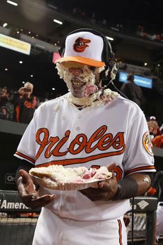 a baseball player is dressed up as a zombie holding a plate with food in it