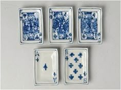 four blue and white plates sitting next to each other on top of a gray surface