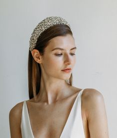 a woman in a white dress wearing a headband with beads on it's side