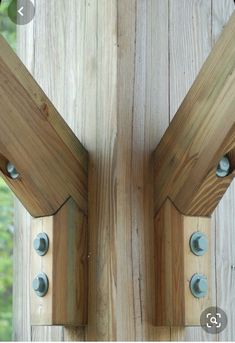 two wooden brackets are attached to the side of a fence