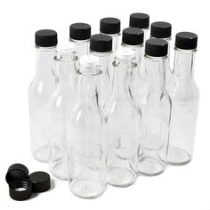 six empty glass bottles with black caps