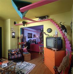 a living room filled with furniture and cats on top of the stairs