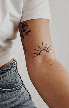 a person with a tattoo on their arm and the sun behind them, in black and white