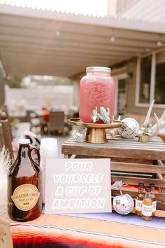 a table topped with jars and bottles filled with liquid next to a sign that says your yourself is cup of amention