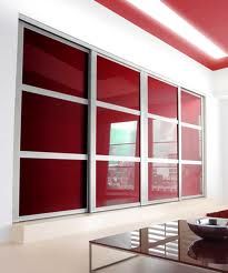 a living room with red and white walls, glass doors and a bowl on the coffee table