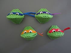 three green crocheted toys with googly eyes on them, one being a frog and the other is a turtle