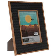 a wooden frame with an image of a bird flying in the sky over mountains and desert