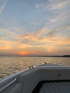 the sun is setting over the water from a boat