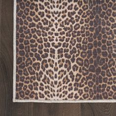 an animal print area rug on top of a wooden floor with wood grains in the background