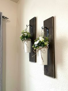 two potted plants are hanging on the wall