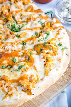 a pizza sitting on top of a cutting board covered in cheese and toppings next to other foods