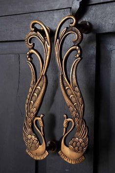 an ornately designed door handle with two swans on it