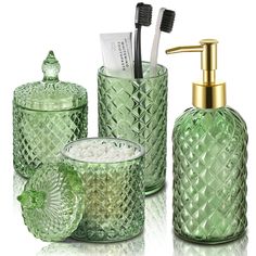 green glass bathroom accessories including toothbrushes and soap dispenser