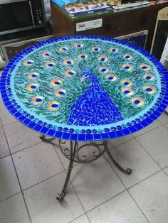 a table with a blue and green peacock design on it's top, in a store