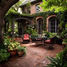 a brick patio with potted plants and chairs on the side, surrounded by greenery