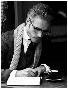 a man sitting at a desk writing on a piece of paper