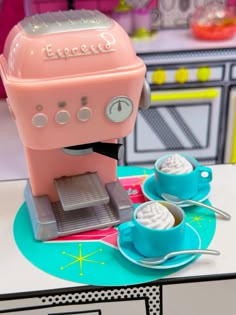 a pink coffee maker sitting on top of a table