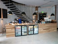 a man standing behind a counter in a restaurant with lots of food and drinks on it