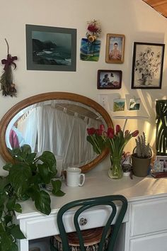 a white desk topped with a mirror and lots of pictures on the wall above it