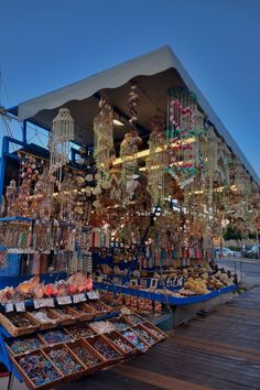 an outdoor market with lots of items for sale on the tables and in front of it are chandeliers