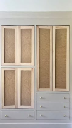 an empty white cabinet with drawers and doors