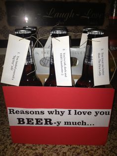 four beer bottles in a red box with white tags on the top, and one is labeled reason why i love you ber - y much