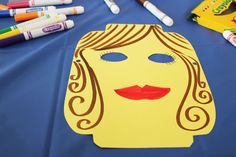 a blue table topped with lots of crayons and markers