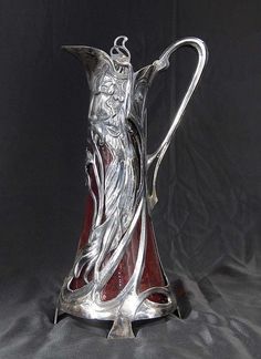 a silver and red vase sitting on top of a table