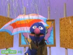 the sesame street show character is holding an umbrella