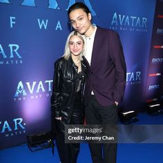 a man and woman standing next to each other on a blue carpet