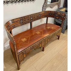 a wooden bench sitting in front of a mirror on top of a hard wood floor