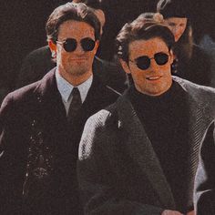 two men in suits and sunglasses walking together