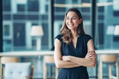 a woman standing in an office with her arms crossed