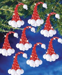 six red and white santa hats hanging from a christmas tree