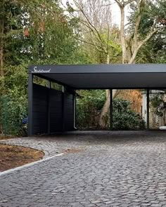 an outdoor covered area in the middle of a park with trees and bushes around it