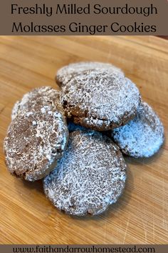 three powdered sourdough molassses on a cutting board with text overlay that reads, freshly milled sourdough molasses ginger cookies