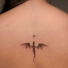 a woman's back with a tattoo on it