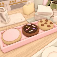 two donuts are in a pink box on the counter next to some other items