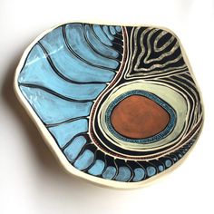 a blue and brown bowl sitting on top of a white table