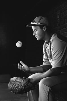 black and white photograph of a baseball player throwing a ball to another player sitting on a bench