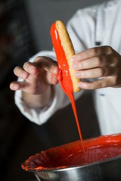 a person pouring sauce onto a piece of bread