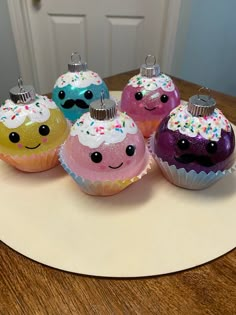 five cupcakes with sprinkles on them sitting on a plate