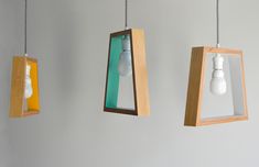 three different colored lights hanging from wooden frames