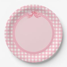 a pink and white checkered plate with a bow on the rim, against a white background