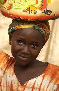 a young woman with a large bowl on her head