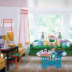 a living room filled with lots of furniture and colorful pillows on top of it's couches