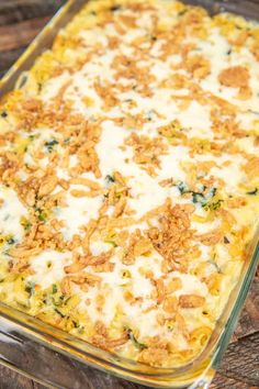 a casserole dish with cheese and other toppings in it on a wooden table