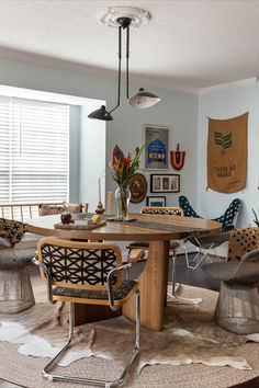 a dining room table with chairs and a rug on the floor in front of it