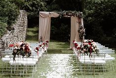 an outdoor ceremony set up with chairs and flowers